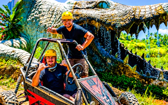 Buggy riders in front of a giant crocodile sculpture on the Ubud Bali adventure tour.