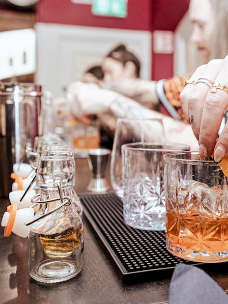 Hands preparing cocktails at the Irish Whiskey Museum masterclass.