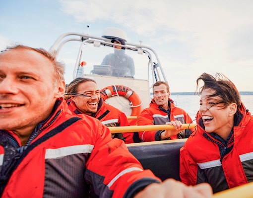 Four people on a Zodiac boat during a whale watching tour in Victoria, Canada.