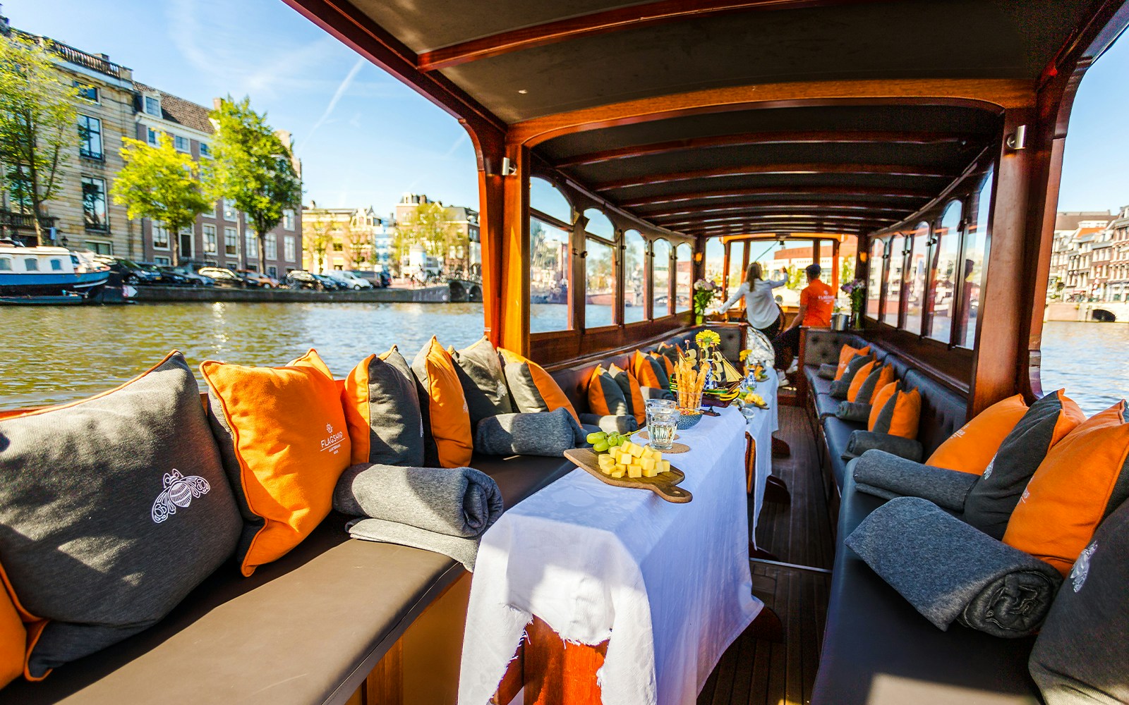 Luxury canal cruise in Amsterdam with cheese and wine setup on a boat.
