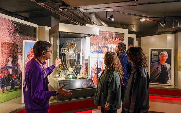 Visitors viewing Premier League trophy at Arsenal Museum, Emirates Stadium.