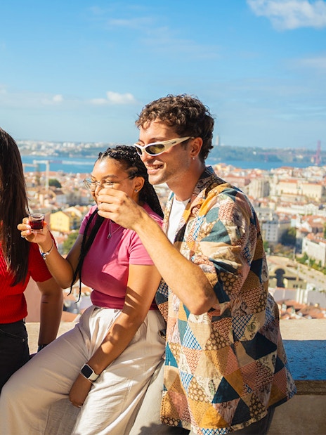 Tourists enjoying drinks at Miradouro da Senhora do Monte viewpoint, Lisbon.