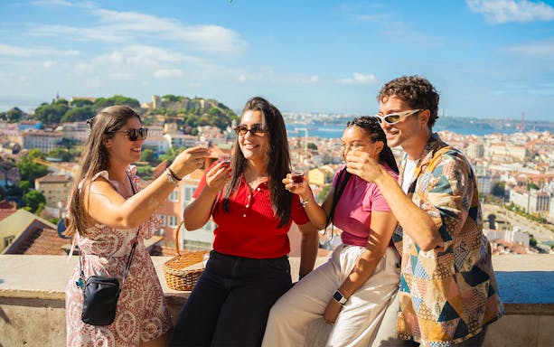 Tourists enjoying drinks at Miradouro da Senhora do Monte viewpoint, Lisbon.