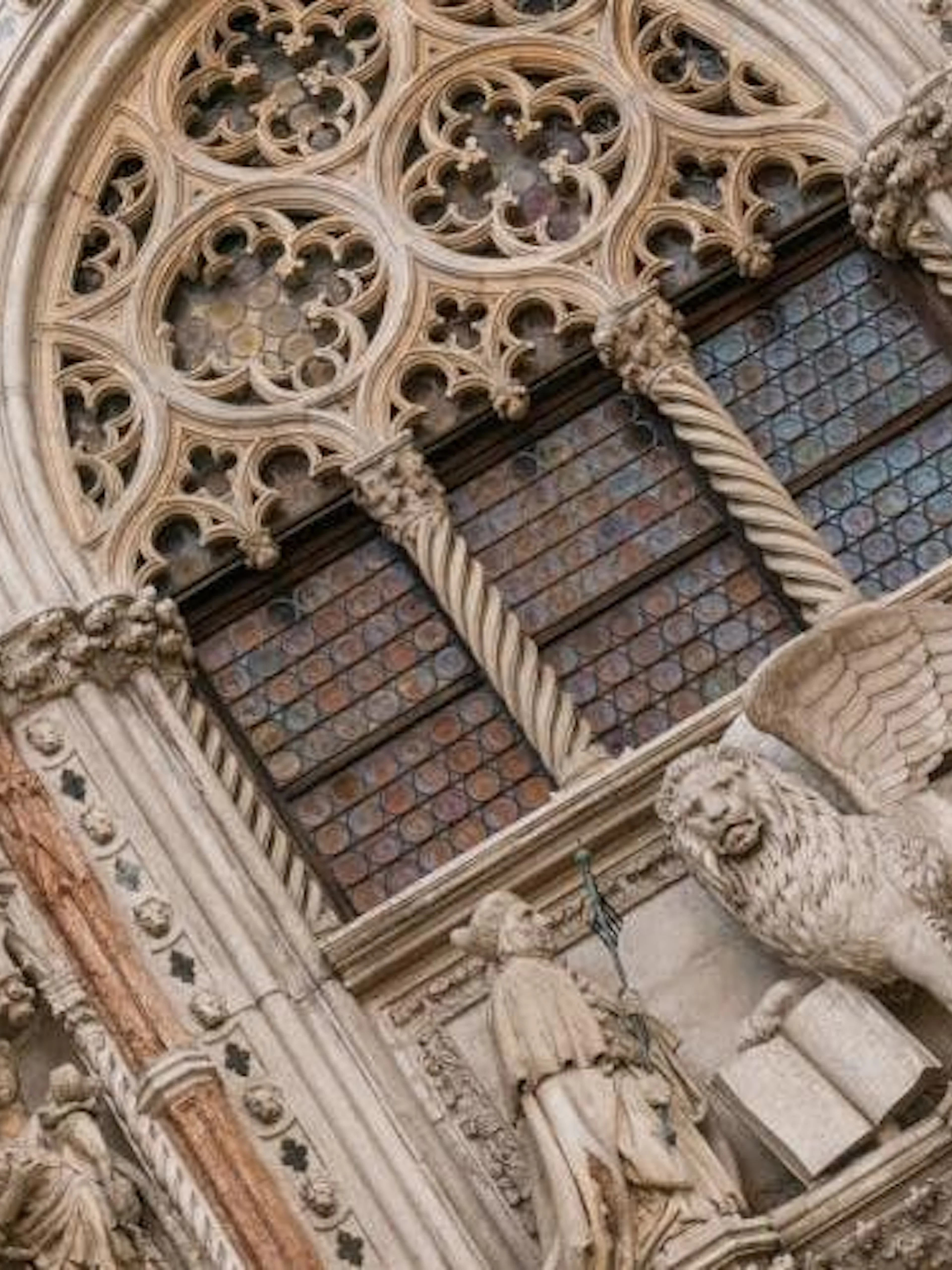 St. Mark's Basilica ornate facade with winged lion sculpture, Venice.