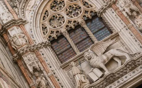 St. Mark's Basilica ornate facade with winged lion sculpture, Venice.