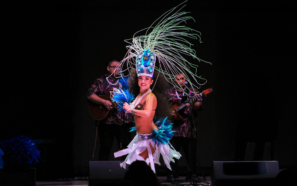 Performer in traditional attire dancing at Moana Luau, Hawaii.