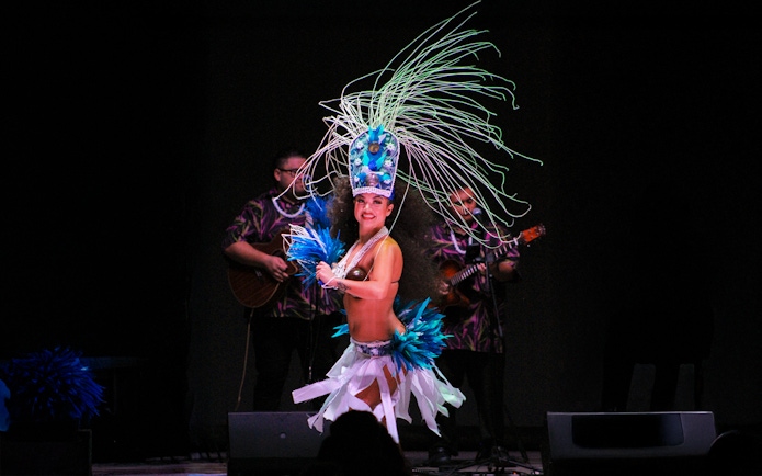 Performer in traditional attire dancing at Moana Luau, Hawaii.