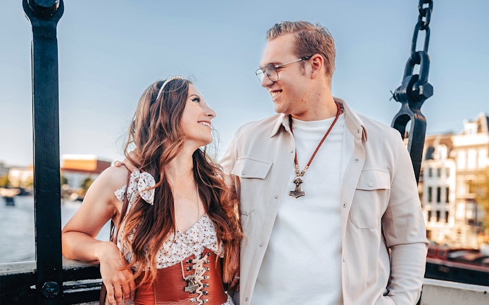 Couple smiling on Magere Brug during professional photoshoot in Amsterdam.