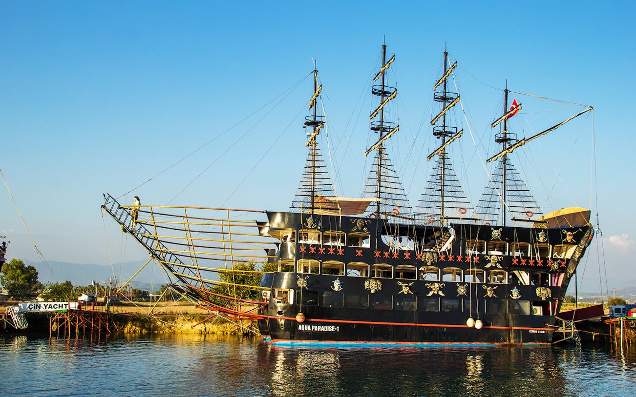 Pirate-themed ship docked on the Manavgat River for a cruise tour.