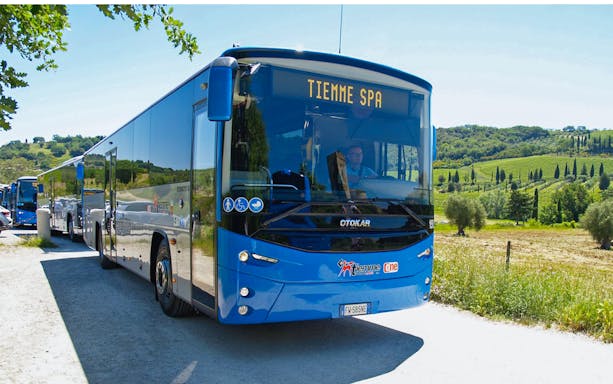 Bus traveling from Siena Central Train Station to Fiumicino Airport, Rome, with scenic countryside.