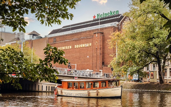 Heineken Brewery with canal cruise boat in Amsterdam.