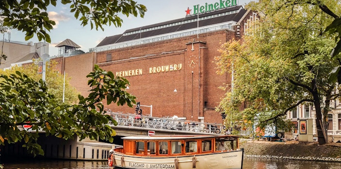 Heineken Brewery with canal cruise boat in Amsterdam.