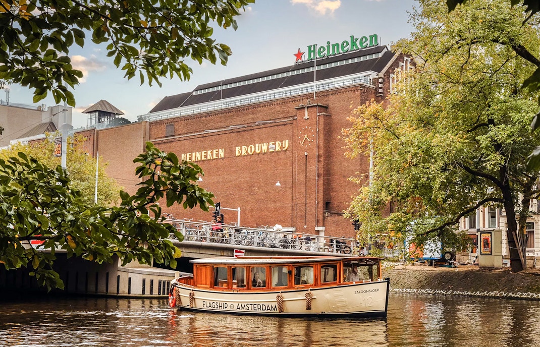 Heineken Brewery with canal cruise boat in Amsterdam.