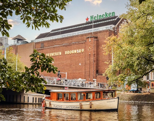Heineken Brewery with canal cruise boat in Amsterdam.