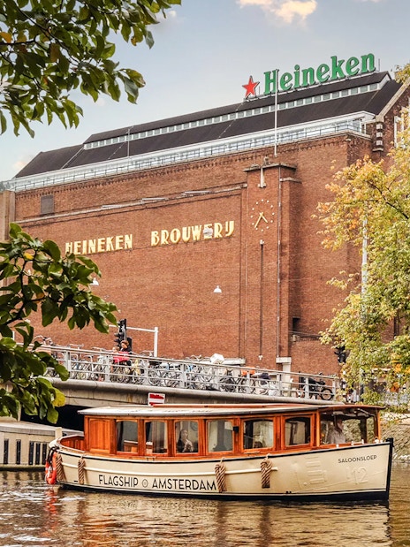 Heineken Brewery with canal cruise boat in Amsterdam.