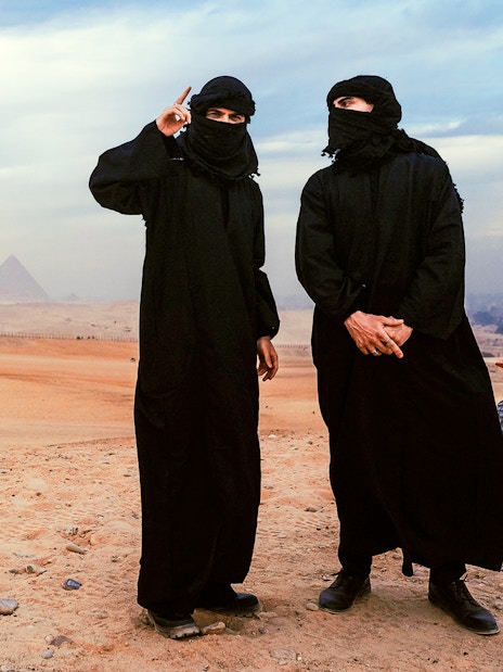 Tourists in traditional attire with ATVs near the Pyramids of Giza, Egypt.