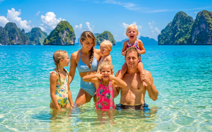 Family enjoying the clear waters of Phi Phi Islands with limestone cliffs in the background.