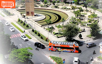 Open-top tour bus near a monument in Ho Chi Minh City, part of the Heritage Sightseeing Loop.