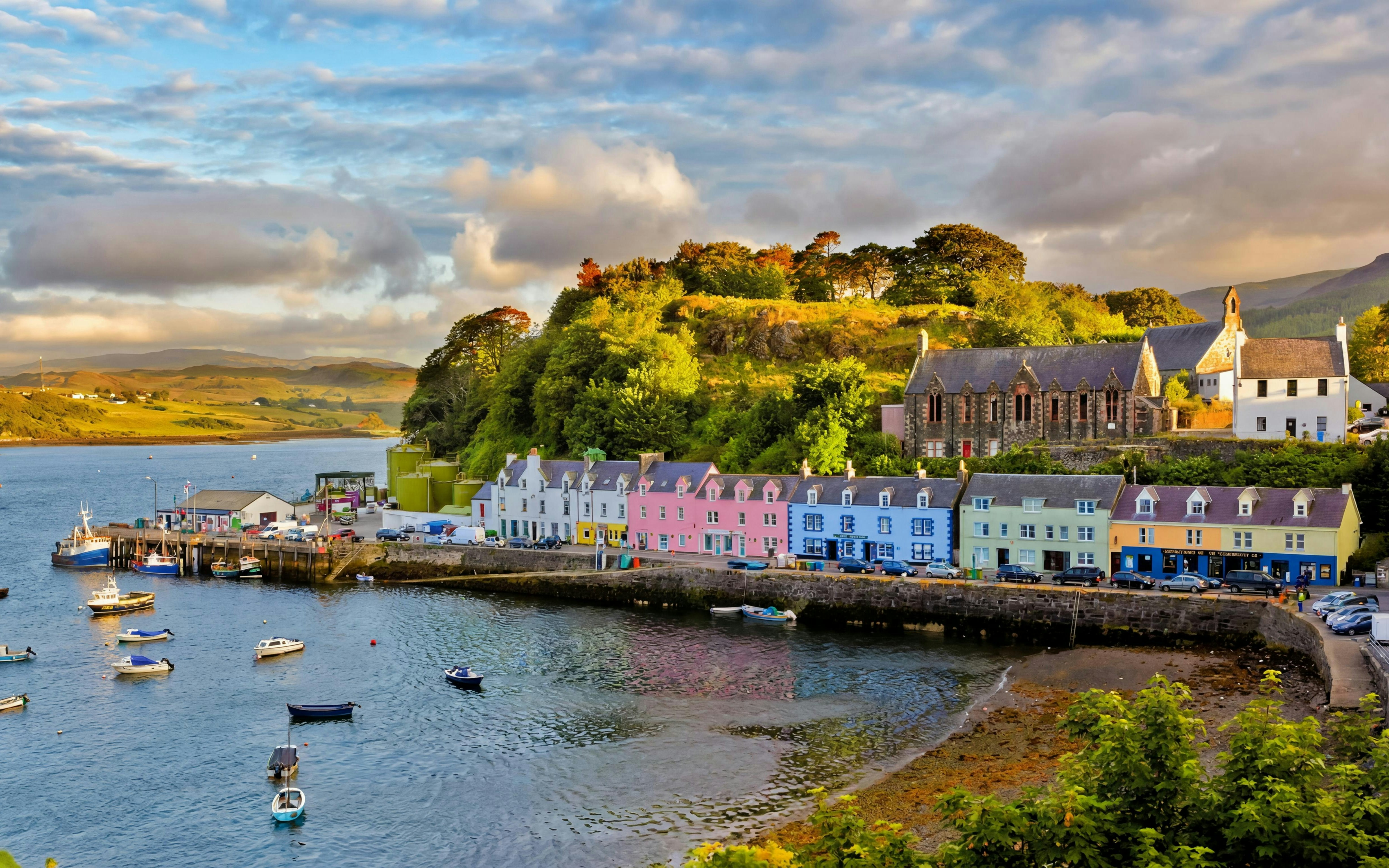 Colorful buildings along Portree harbor, Isle of Skye, with boats in the water.