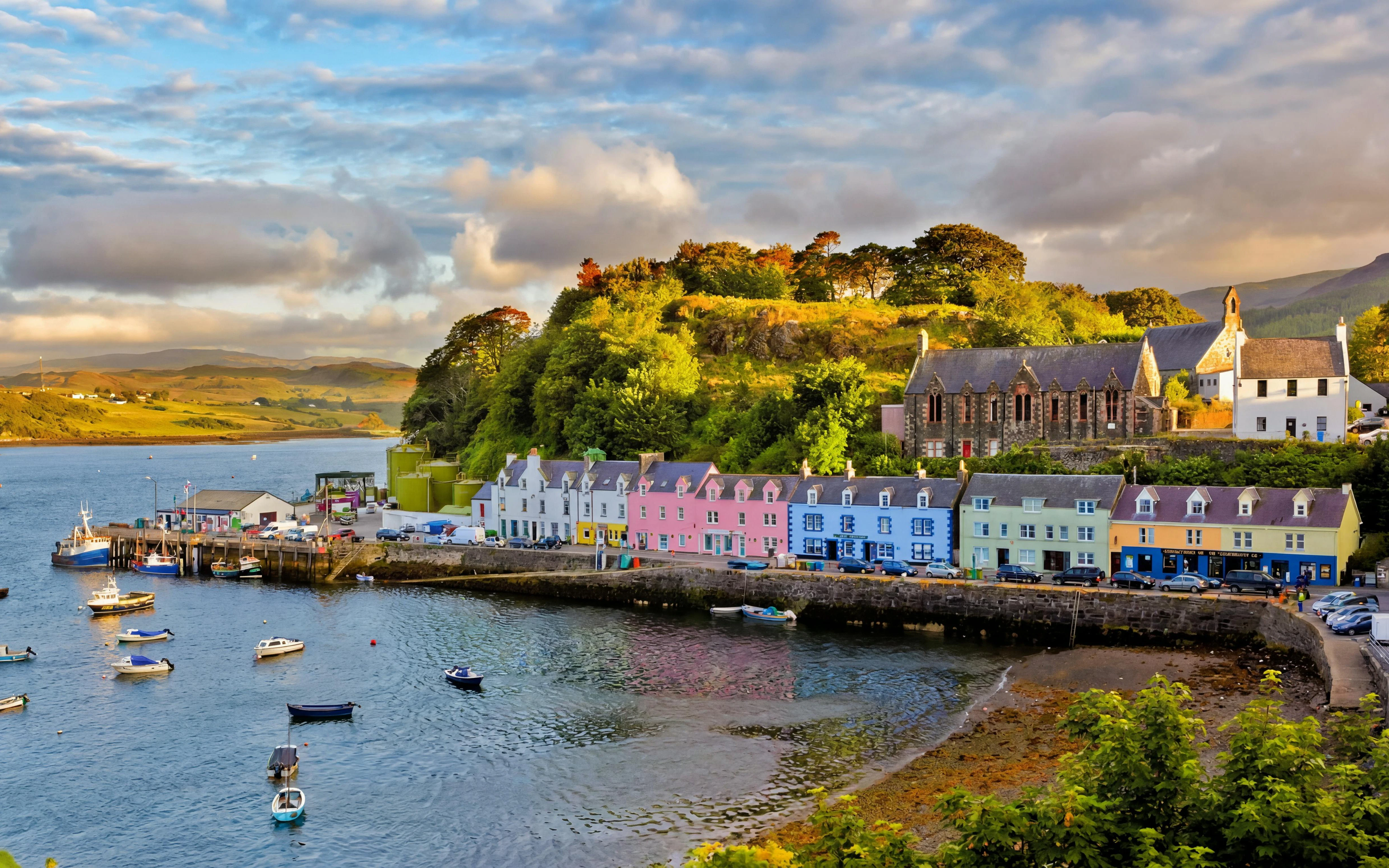 Colorful buildings along Portree harbor, Isle of Skye, with boats in the water.