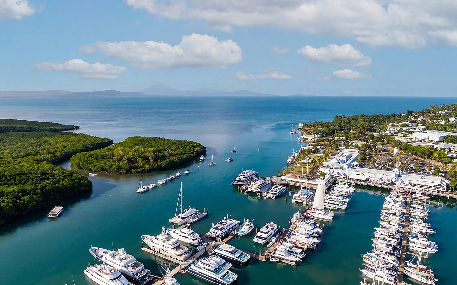 Aerial view of yachts and boats at Cairns Port Douglas marina with mountain landscape, Queenstown, Australia.