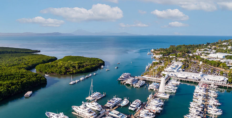 Aerial view of yachts and boats at Cairns Port Douglas marina with mountain landscape, Queenstown, Australia.