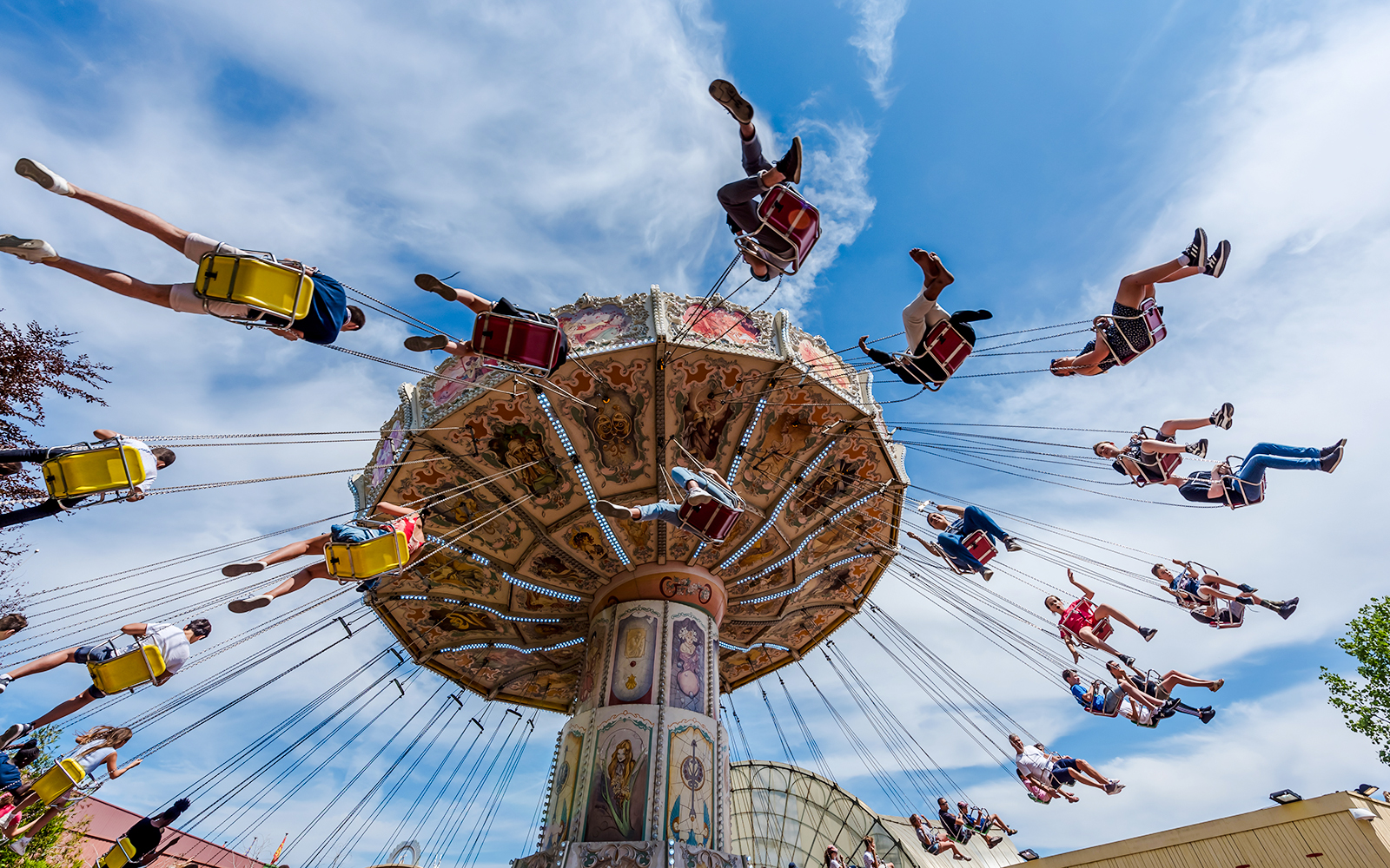 Visitors enjoying a swing ride at Parc Asterix under a clear blue sky.