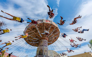 Visitors enjoying a swing ride at Parc Asterix under a clear blue sky.
