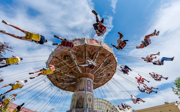 Visitors enjoying a swing ride at Parc Asterix under a clear blue sky.
