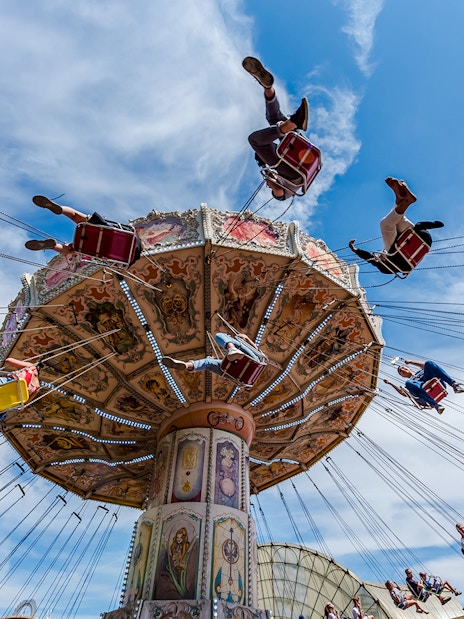 Visitors enjoying a swing ride at Parc Asterix under a clear blue sky.