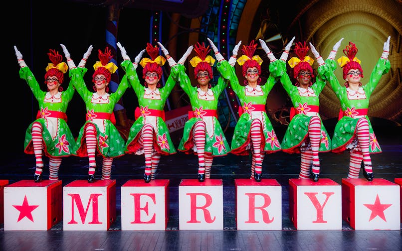 Rockettes performing in festive costumes at Radio City Christmas Spectacular.