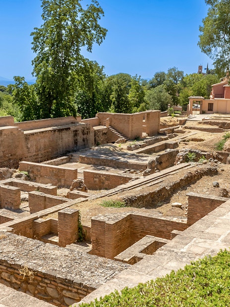 Ancient ruins surrounded by greenery on the Alhambra Surroundings Tour.