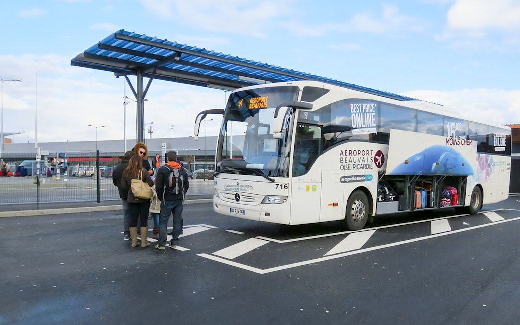 Passengers boarding bus at Paris Beauvais airport bus stop.