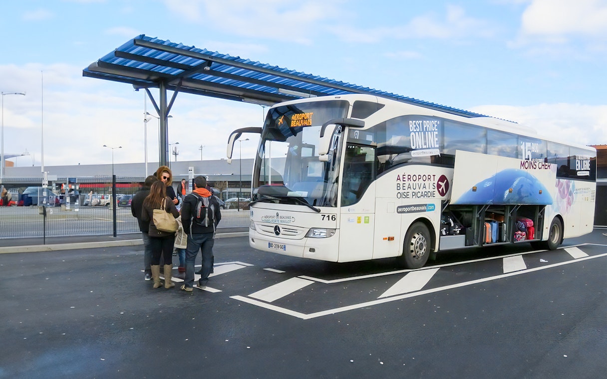Passengers boarding bus at Paris Beauvais airport bus stop.