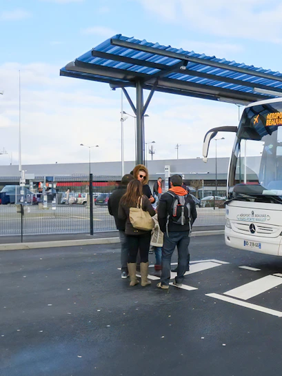 Passengers boarding bus at Paris Beauvais airport bus stop.