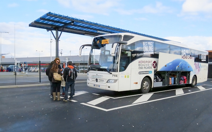 Passengers boarding bus at Paris Beauvais airport bus stop.