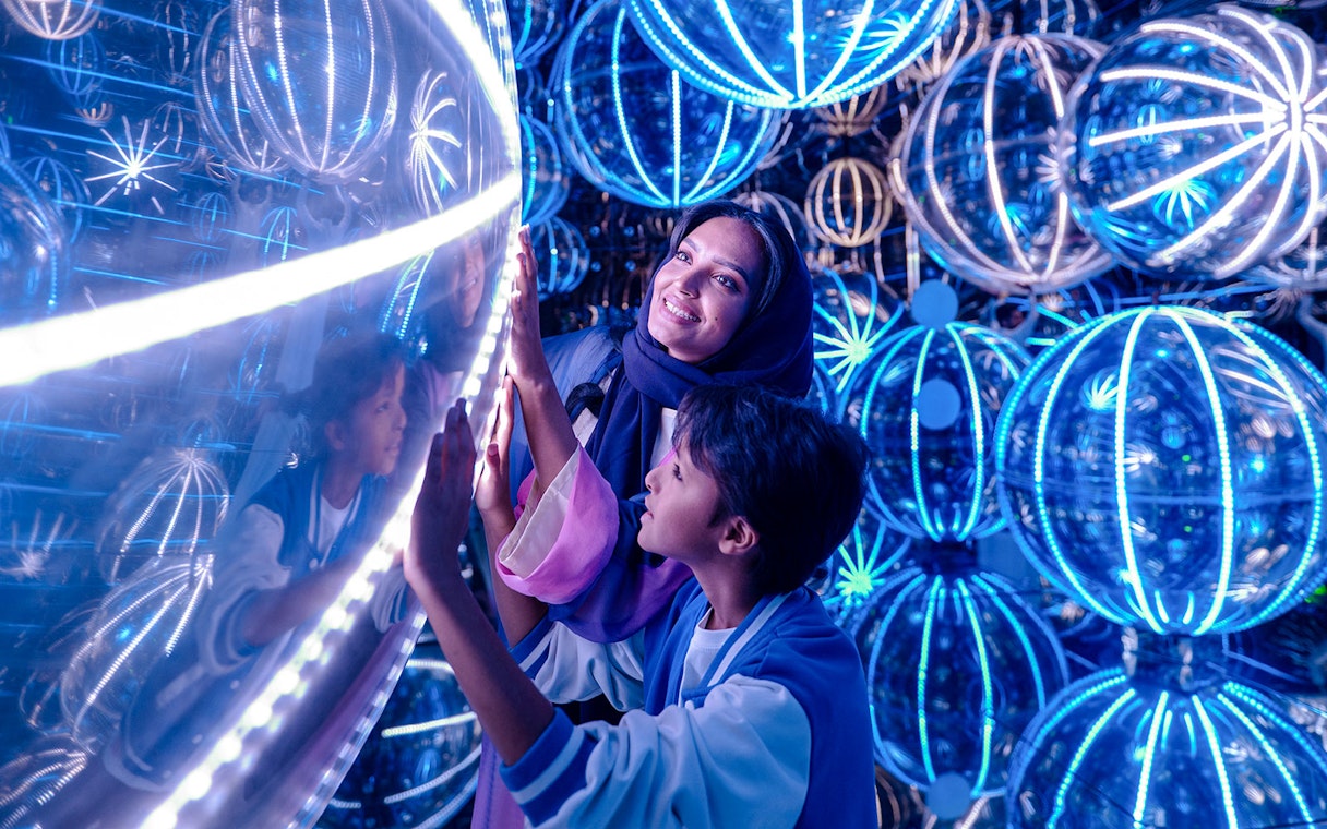 Visitors exploring illuminated spheres at House of Hype exhibit.