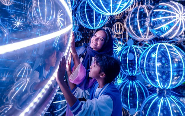 Visitors exploring illuminated spheres at House of Hype exhibit.