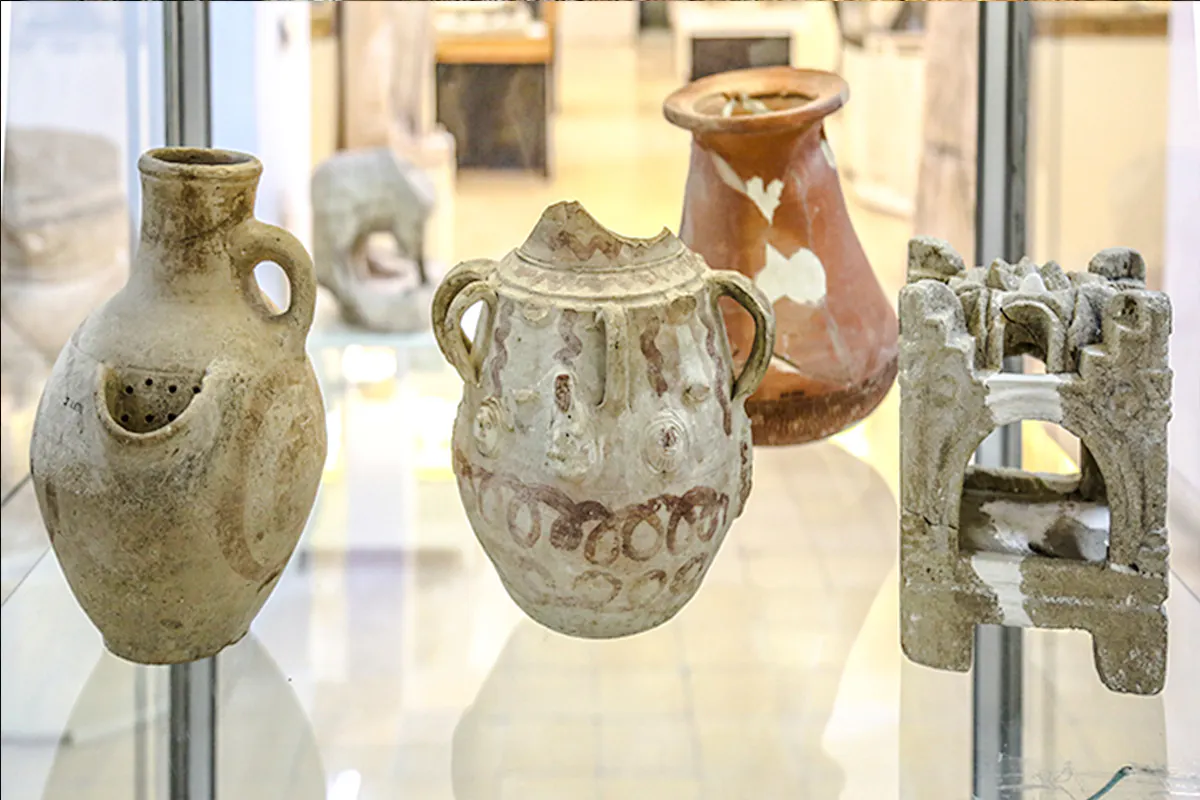 Ancient pottery artifacts displayed in Amman museum during city sightseeing tour.