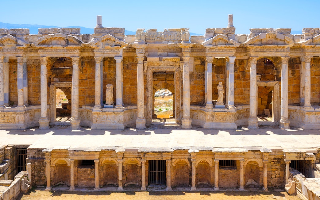 Ancient amphitheater facade with columns and statues in Hierapolis, Turkey.