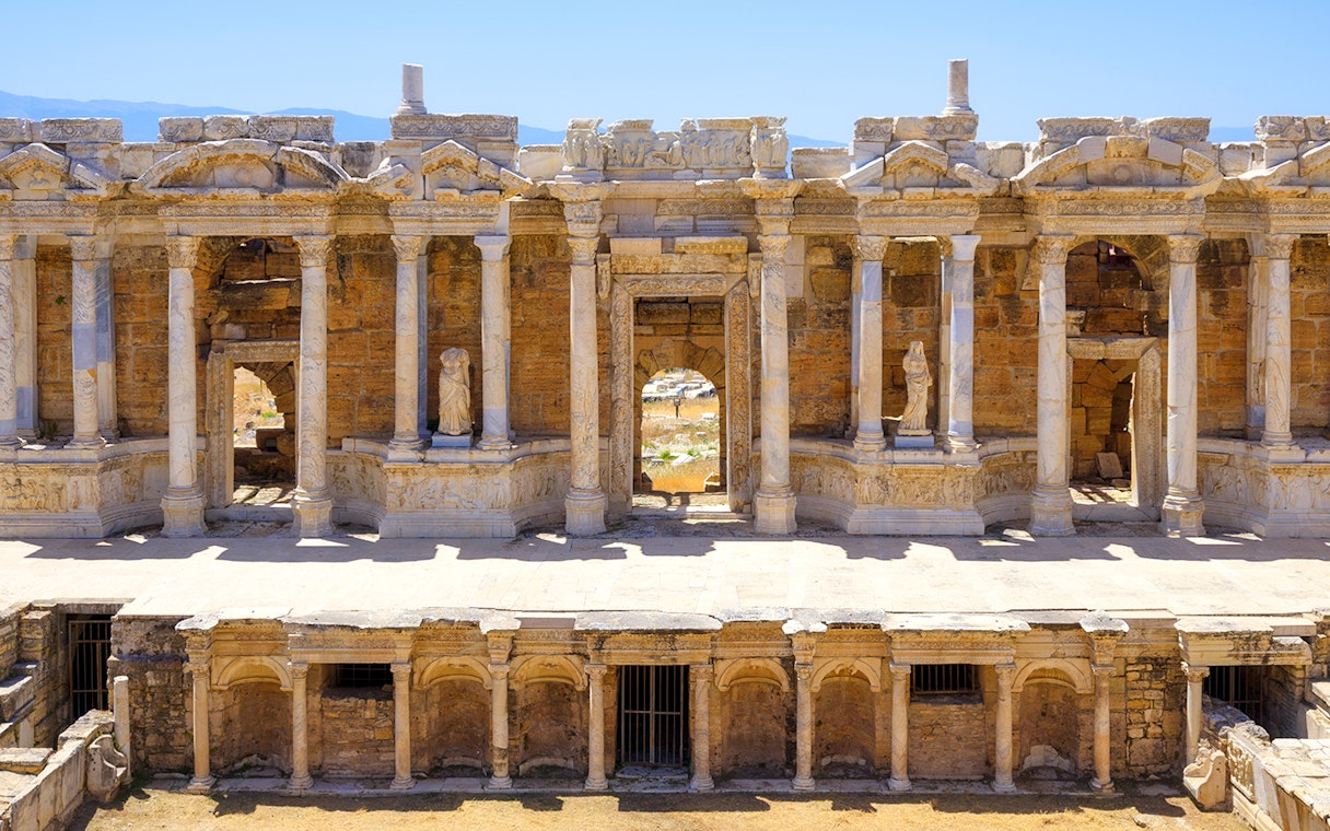 Ancient amphitheater facade with columns and statues in Hierapolis, Turkey.