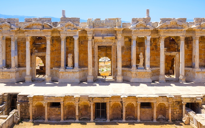 Ancient amphitheater facade with columns and statues in Hierapolis, Turkey.