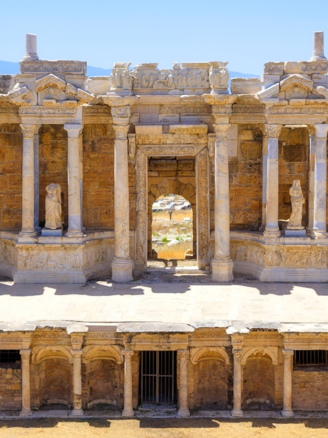 Ancient amphitheater facade with columns and statues in Hierapolis, Turkey.