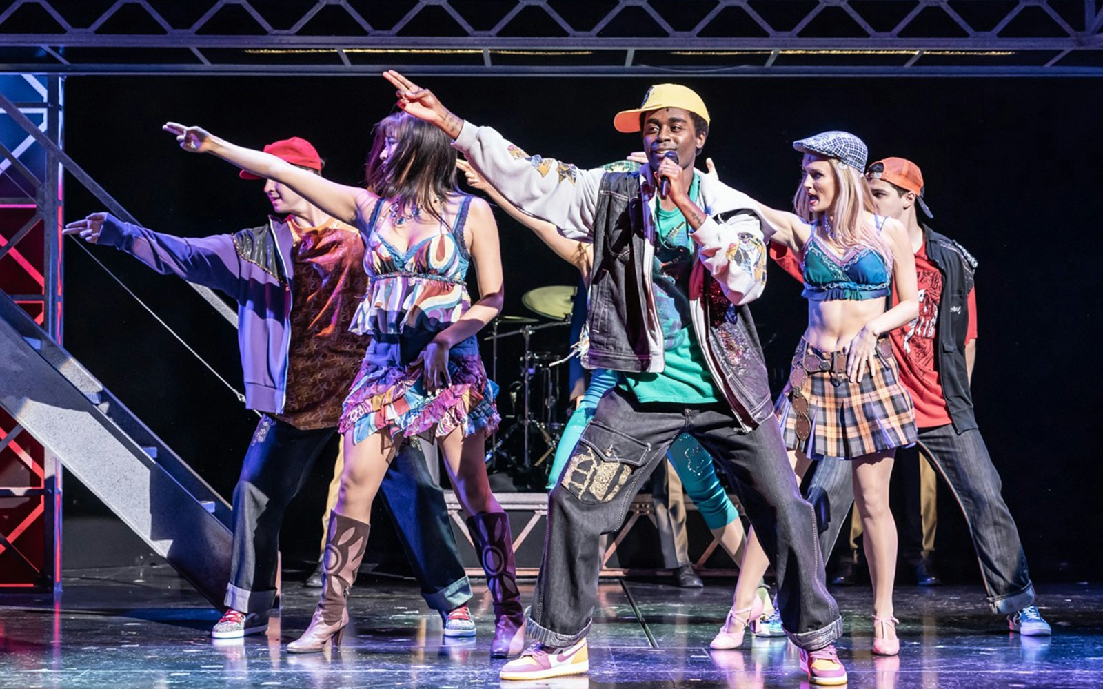 Performers dancing energetically on stage during a Jersey Boys musical scene.