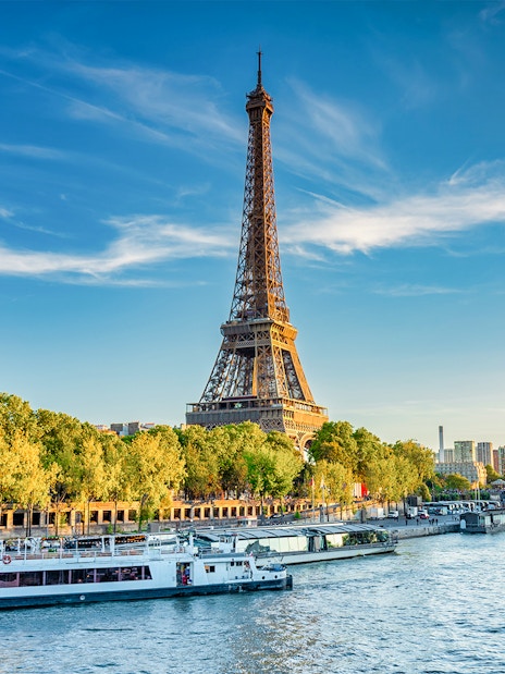 Eiffel Tower beside the Seine River with boats in Paris, France.