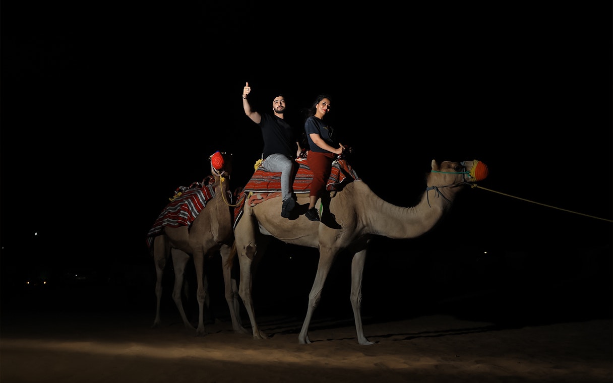 Camel ride at night during Arabian Dunes Premium Safari with Bedouin Camp Experience.