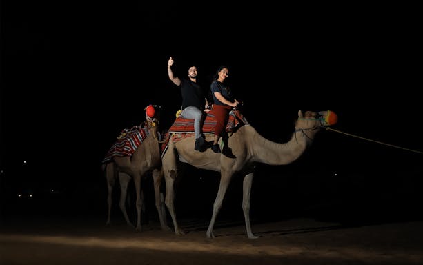 Camel ride at night during Arabian Dunes Premium Safari with Bedouin Camp Experience.