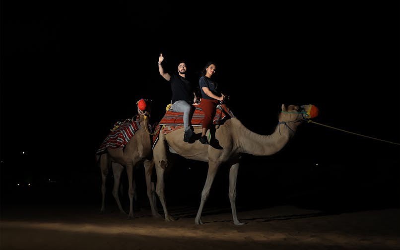 Camel ride at night during Arabian Dunes Premium Safari with Bedouin Camp Experience.