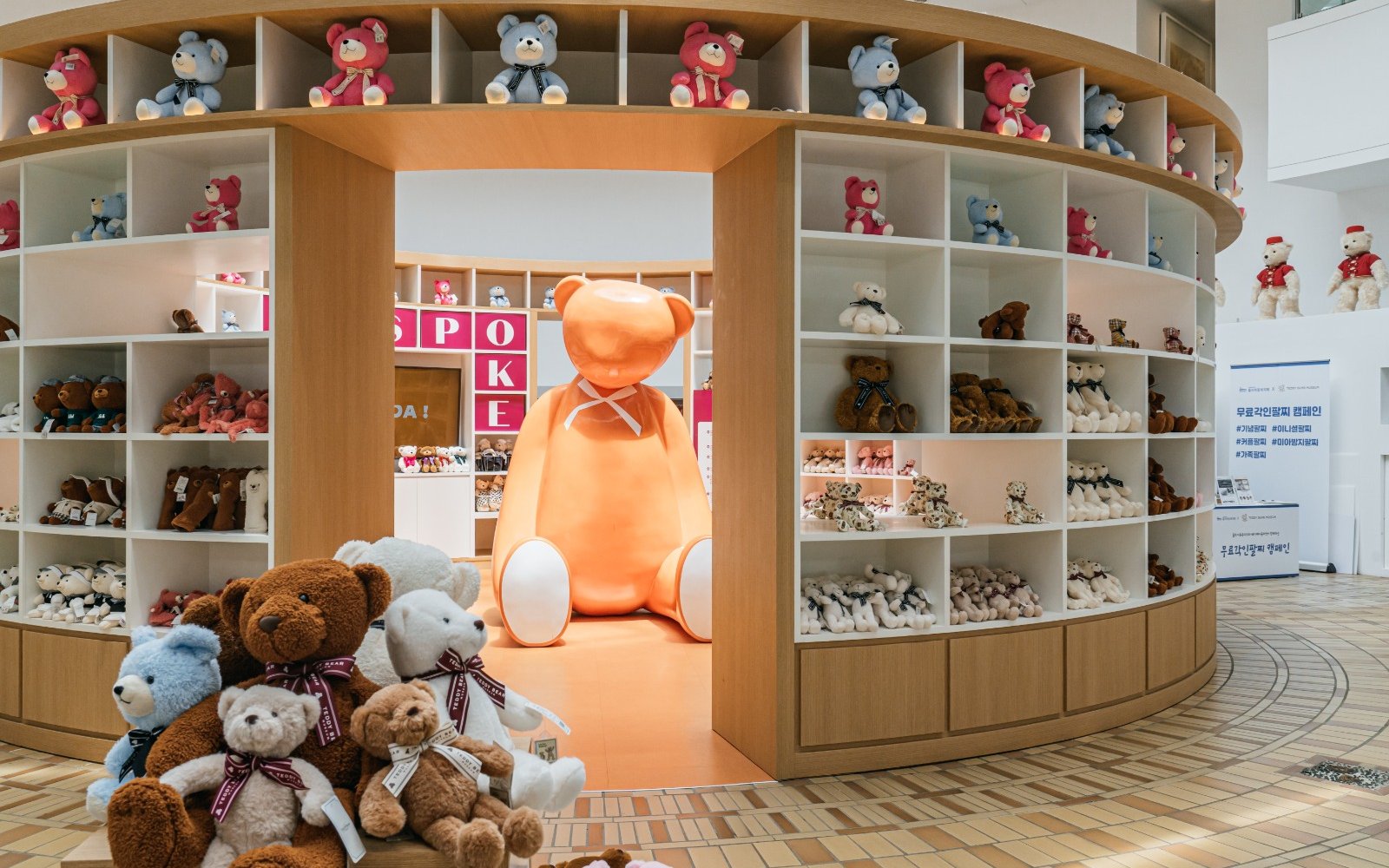 Teddy Bear Museum display with large orange bear and shelves of plush toys.