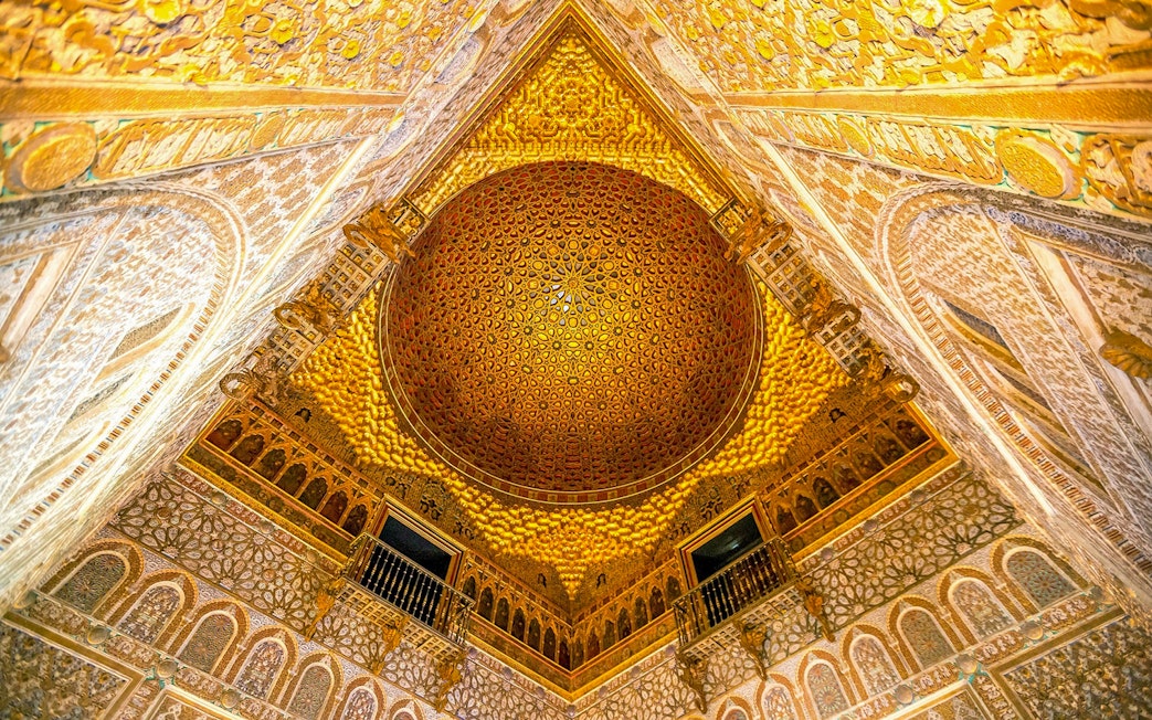 Intricate ceiling of the Alcazar of Seville with detailed geometric patterns.